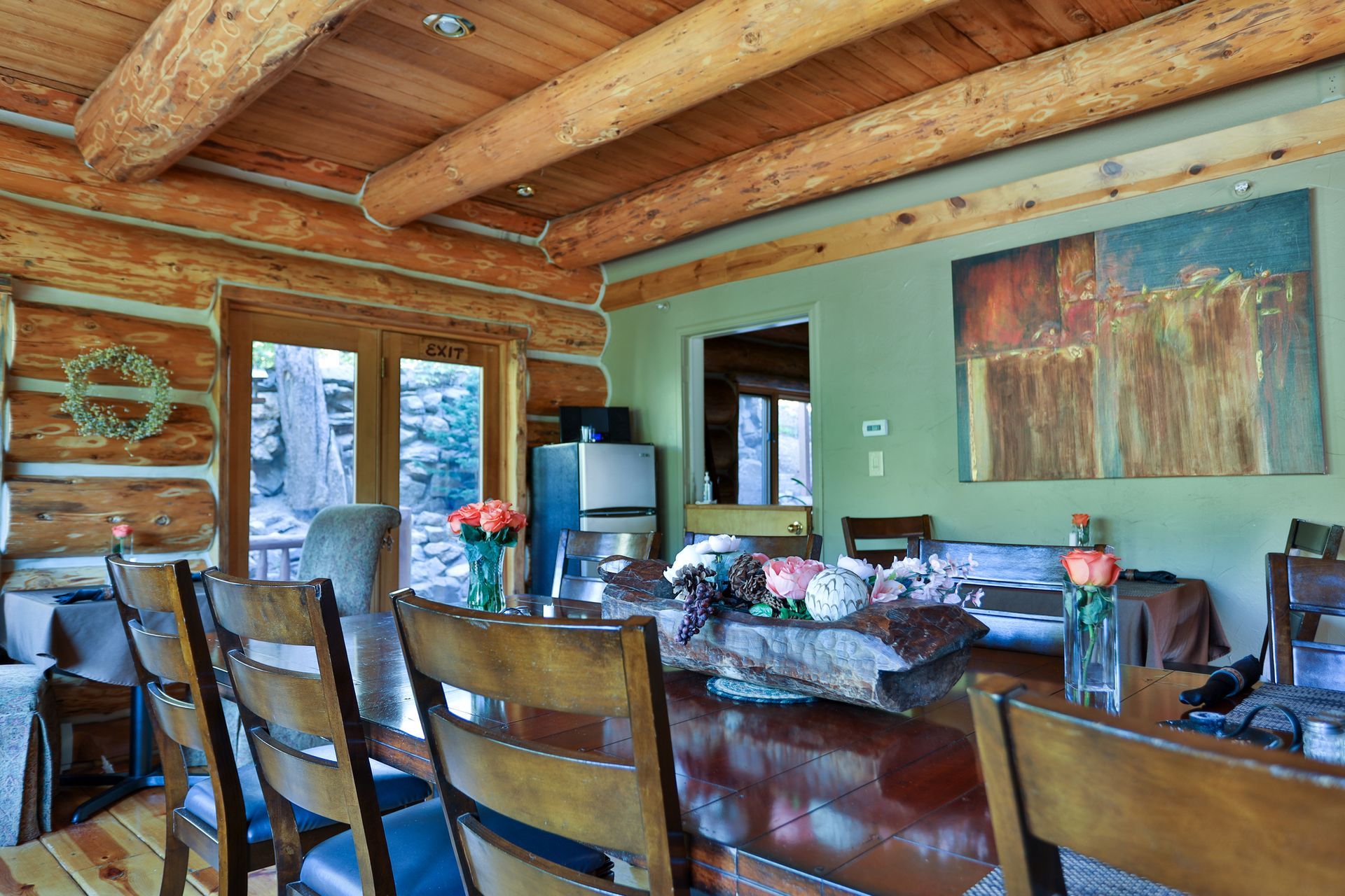 A dining room in a log cabin with a long table and chairs