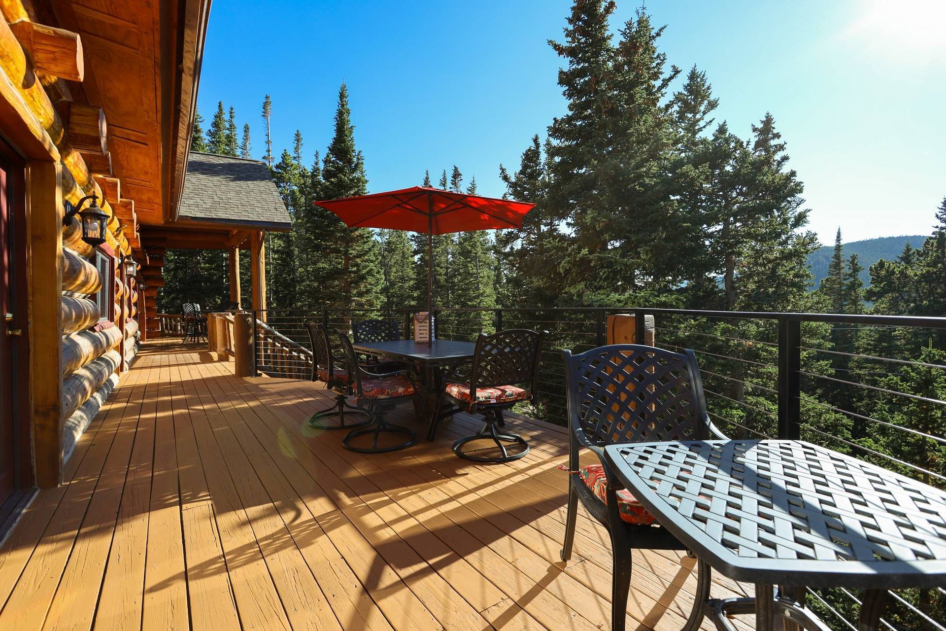 A wooden deck with a table and chairs and an umbrella.