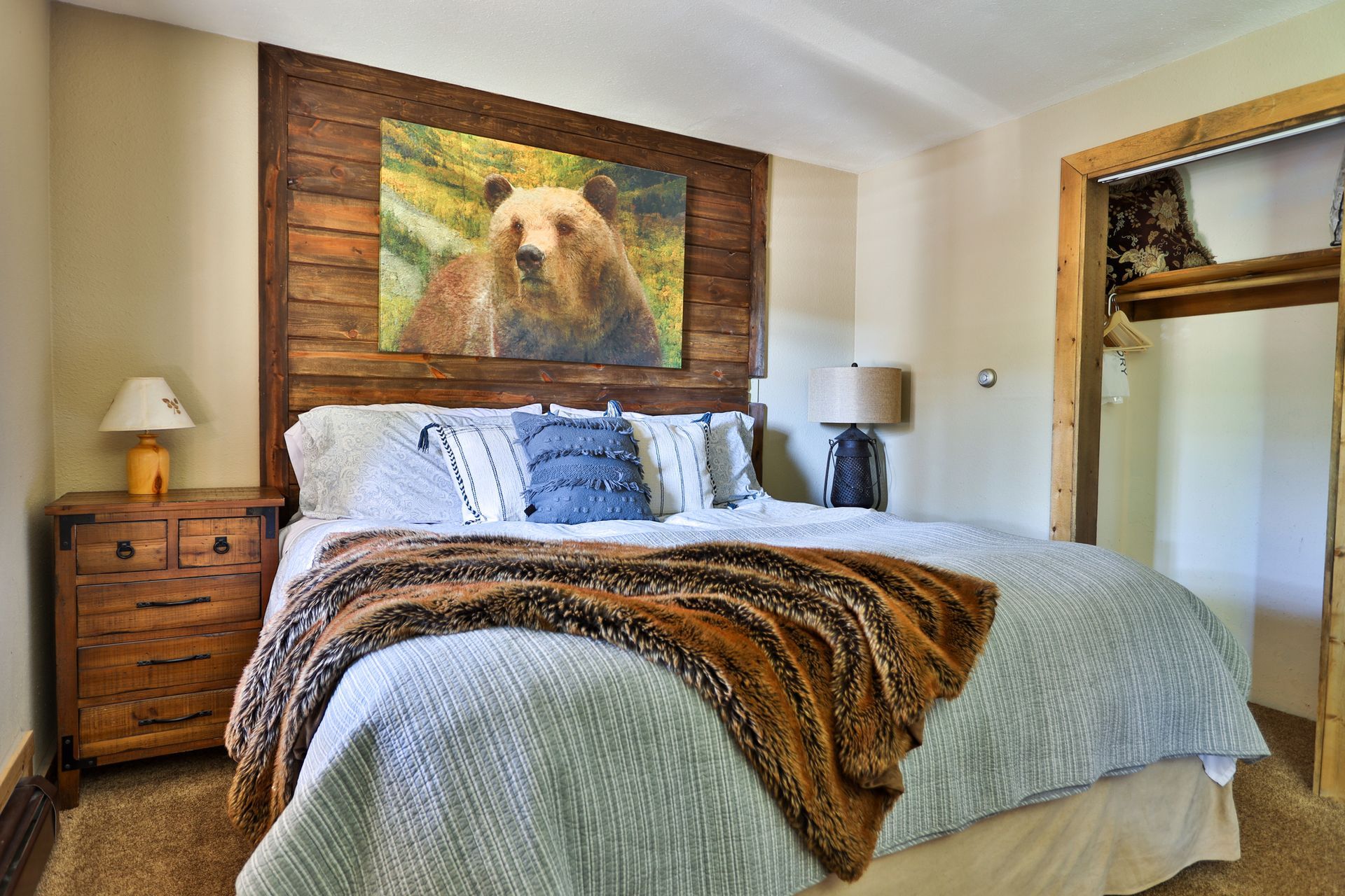 There is a painting of a bear on the wall above the bed.