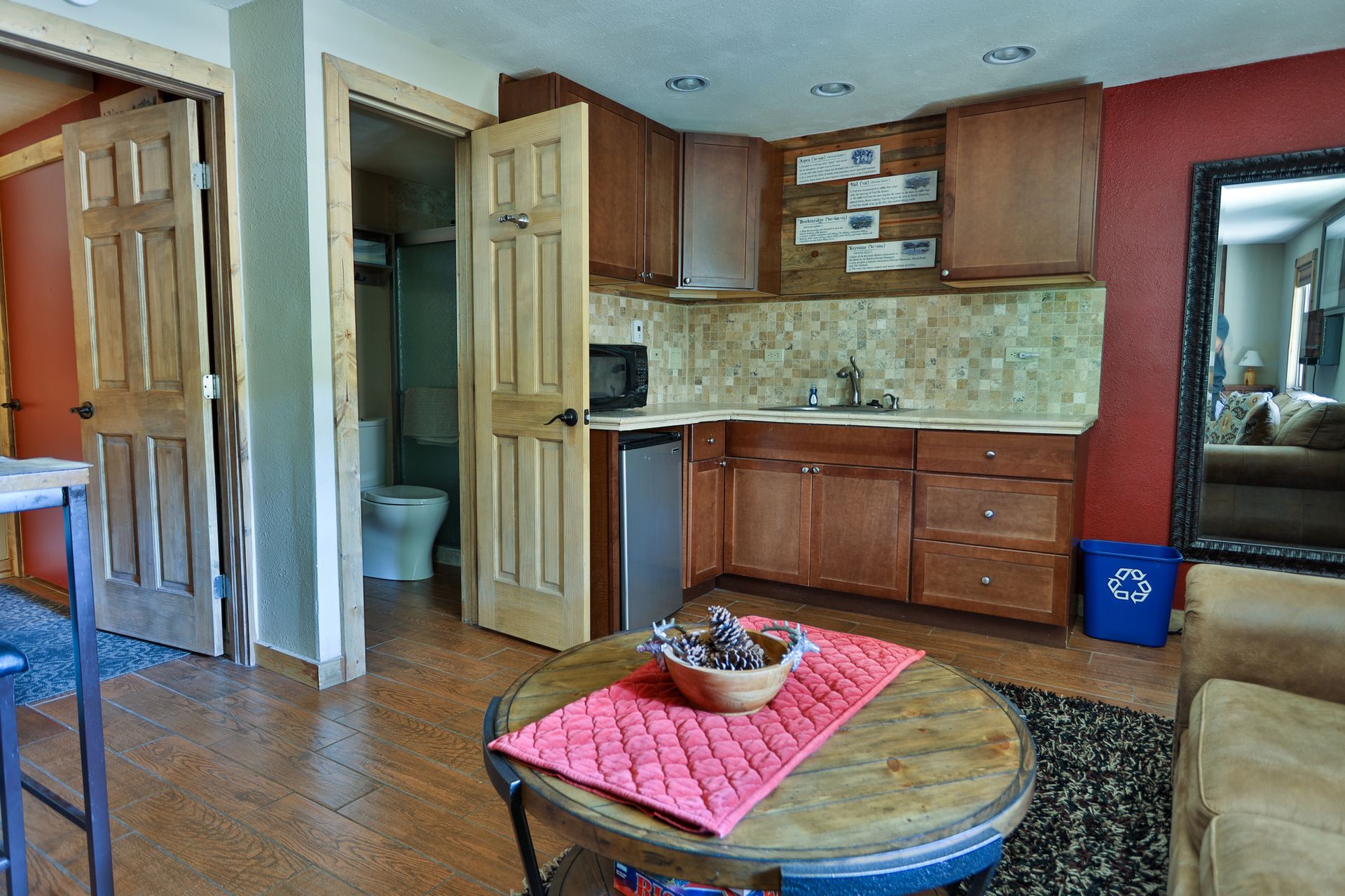 A living room with a table , chairs , and a kitchen.