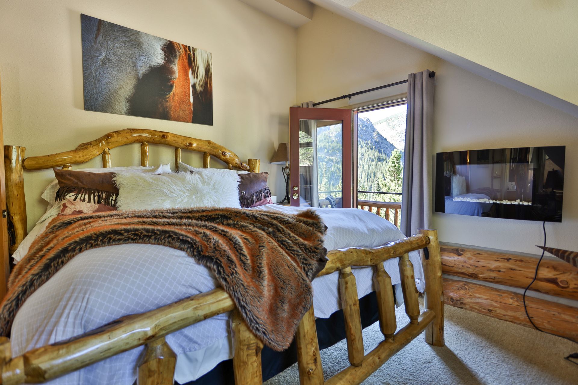 A bedroom with a log bed and a fireplace.