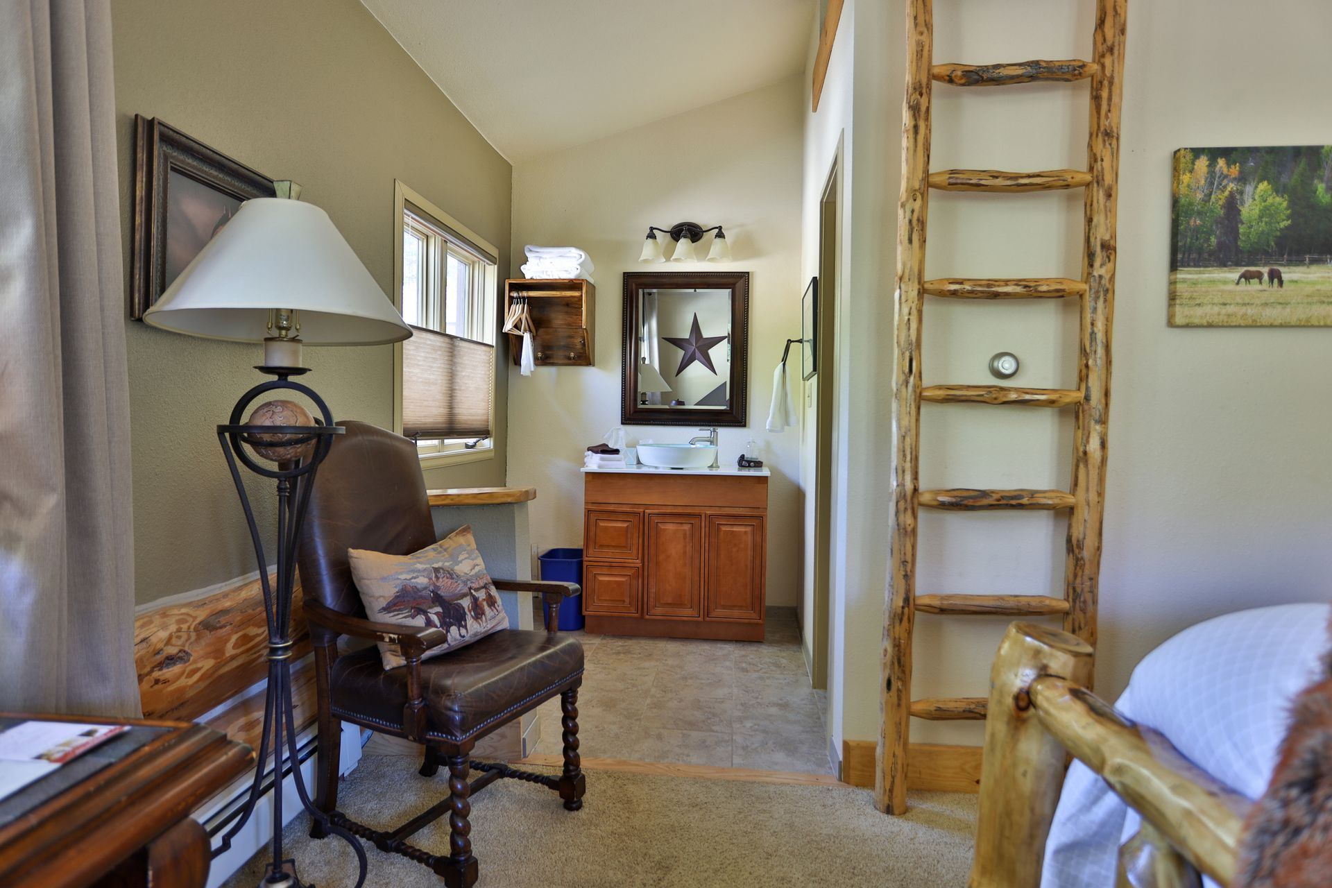 A bedroom with a chair , lamp , and ladder.