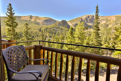 A balcony with a view of mountains and trees