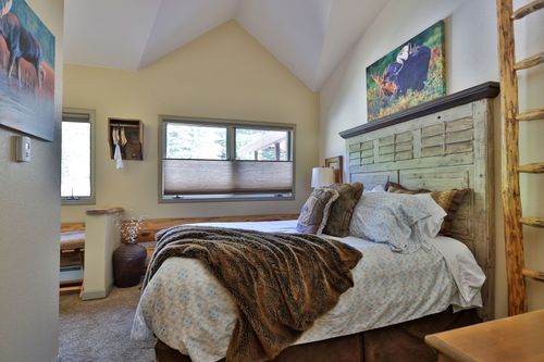 A bedroom with a king size bed and a painting on the wall.