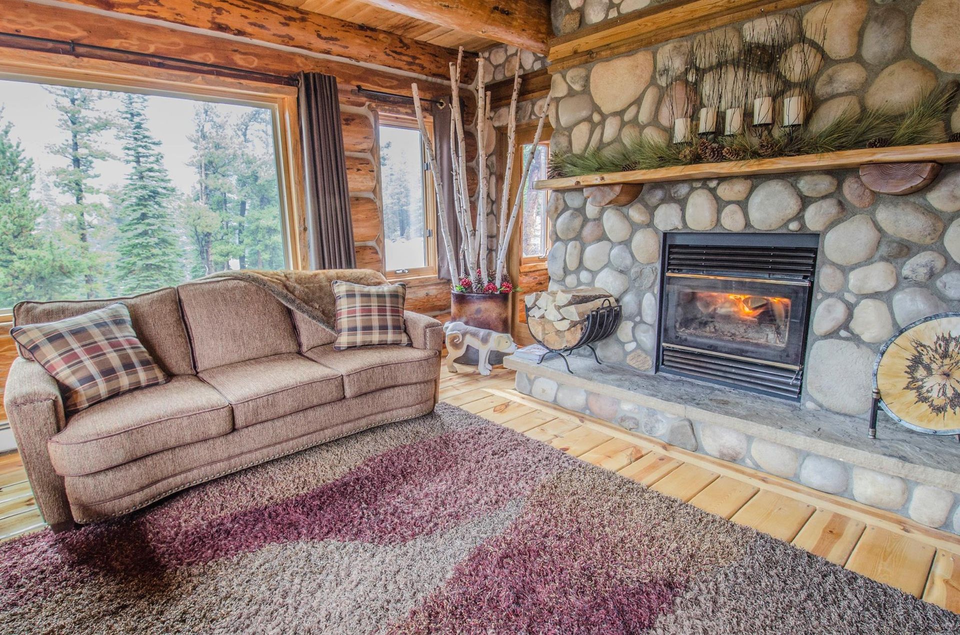 A living room in a log cabin with a couch and fireplace.