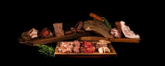Composizione di tartare di fragole, formaggio, aceto balsamico e scorza d'arancia su fondo nero.