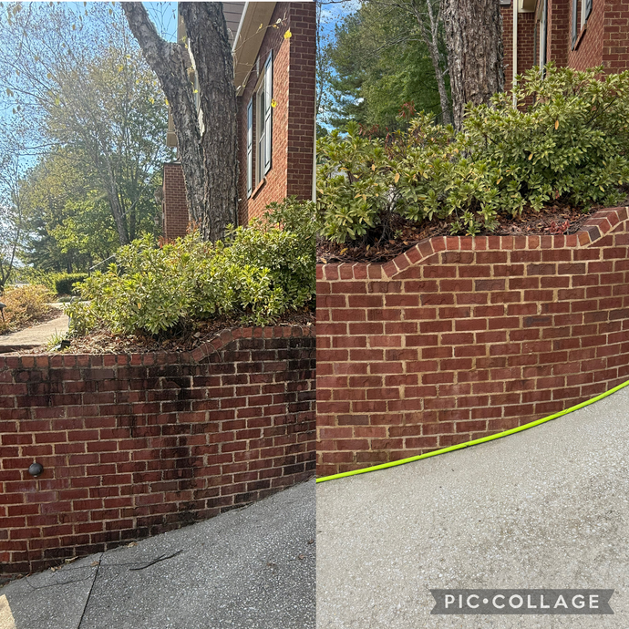 Brick house with stairs leading up from a concrete driveway. Garage visible.