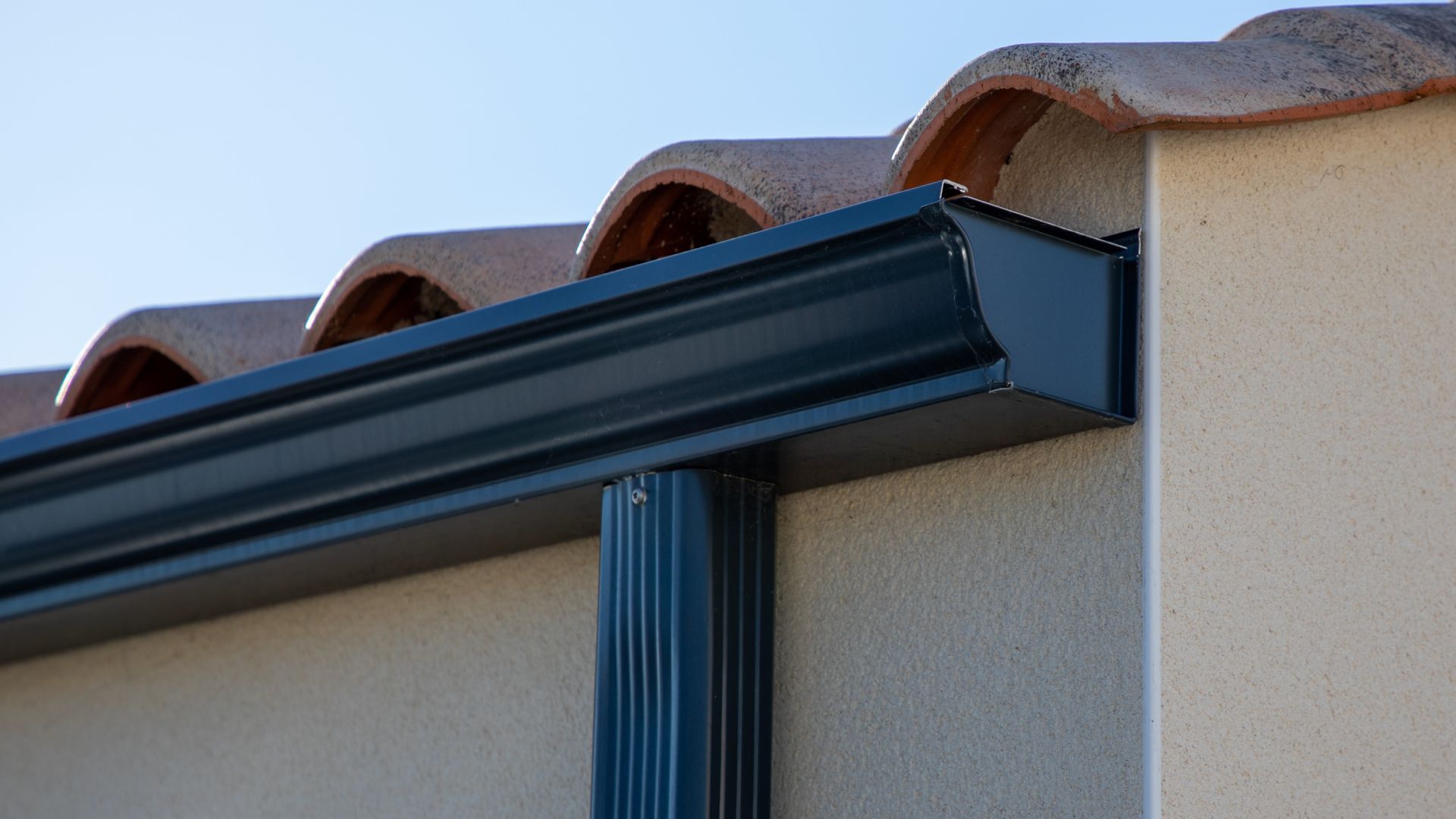 A close up of a gutter on the side of a building.