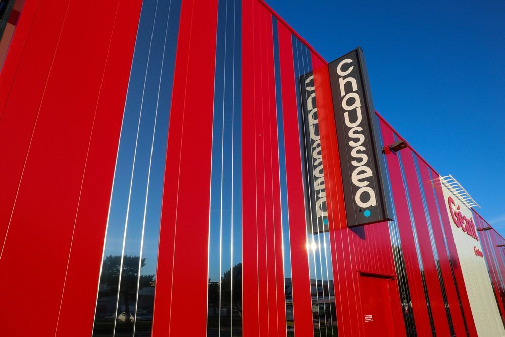 Bâtiment rouge aux panneaux miroirs ; une enseigne indique « Cirque du Soleil » sur fond de ciel bleu.