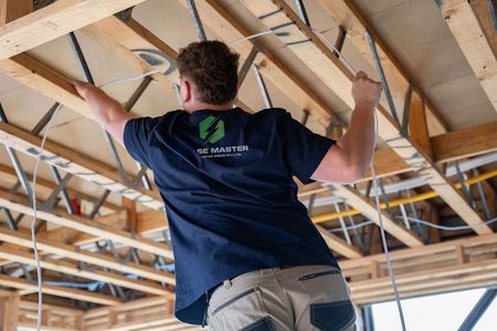A man is working on the ceiling of a building.
