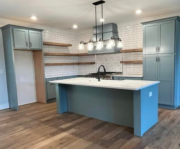 A kitchen with blue cabinets and a large island.