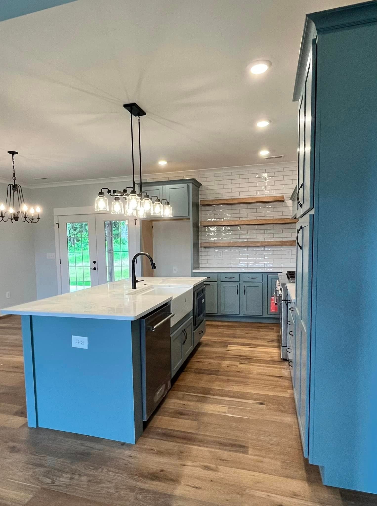 A kitchen with blue cabinets and a large island in the middle.