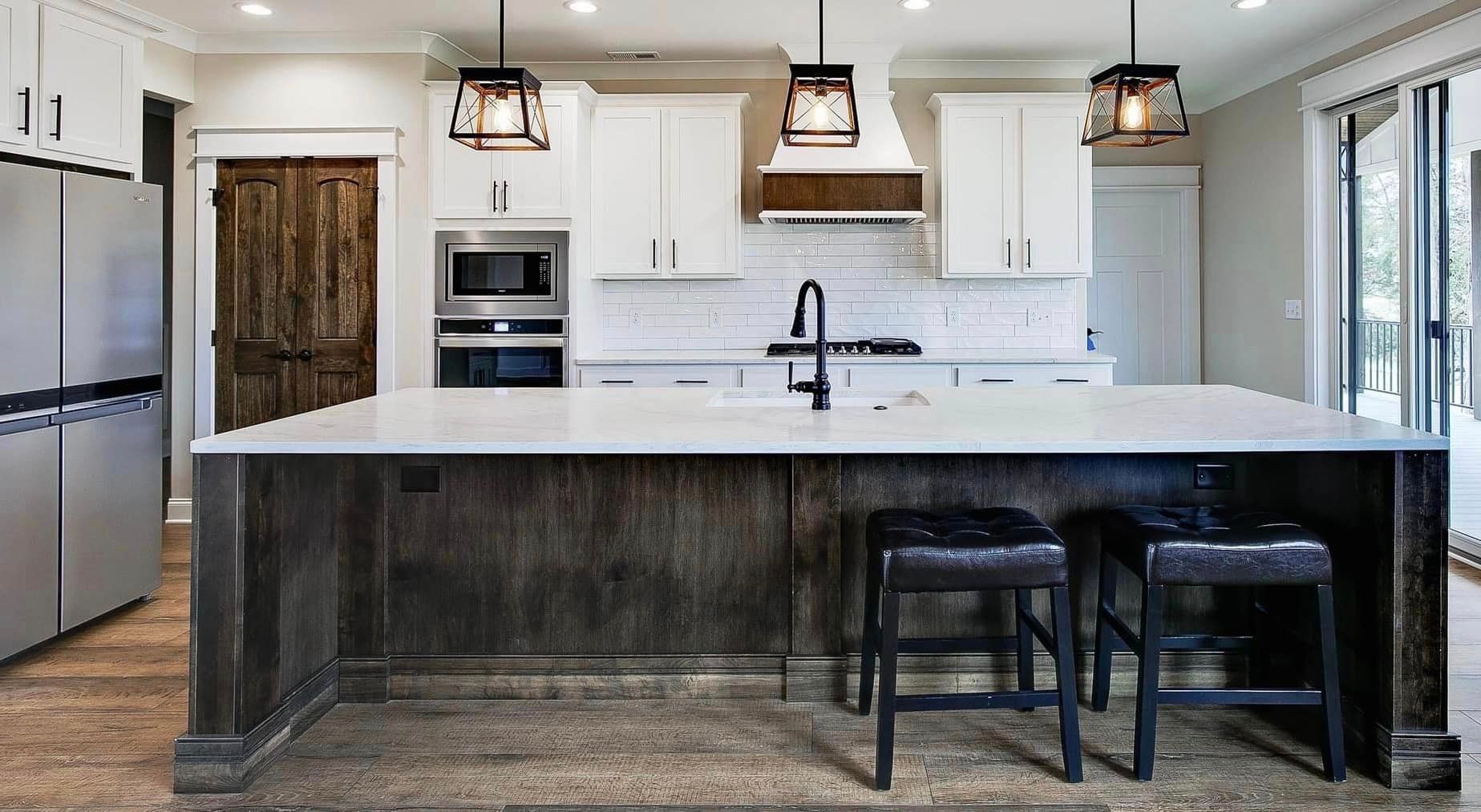 A kitchen with a large island and stools.