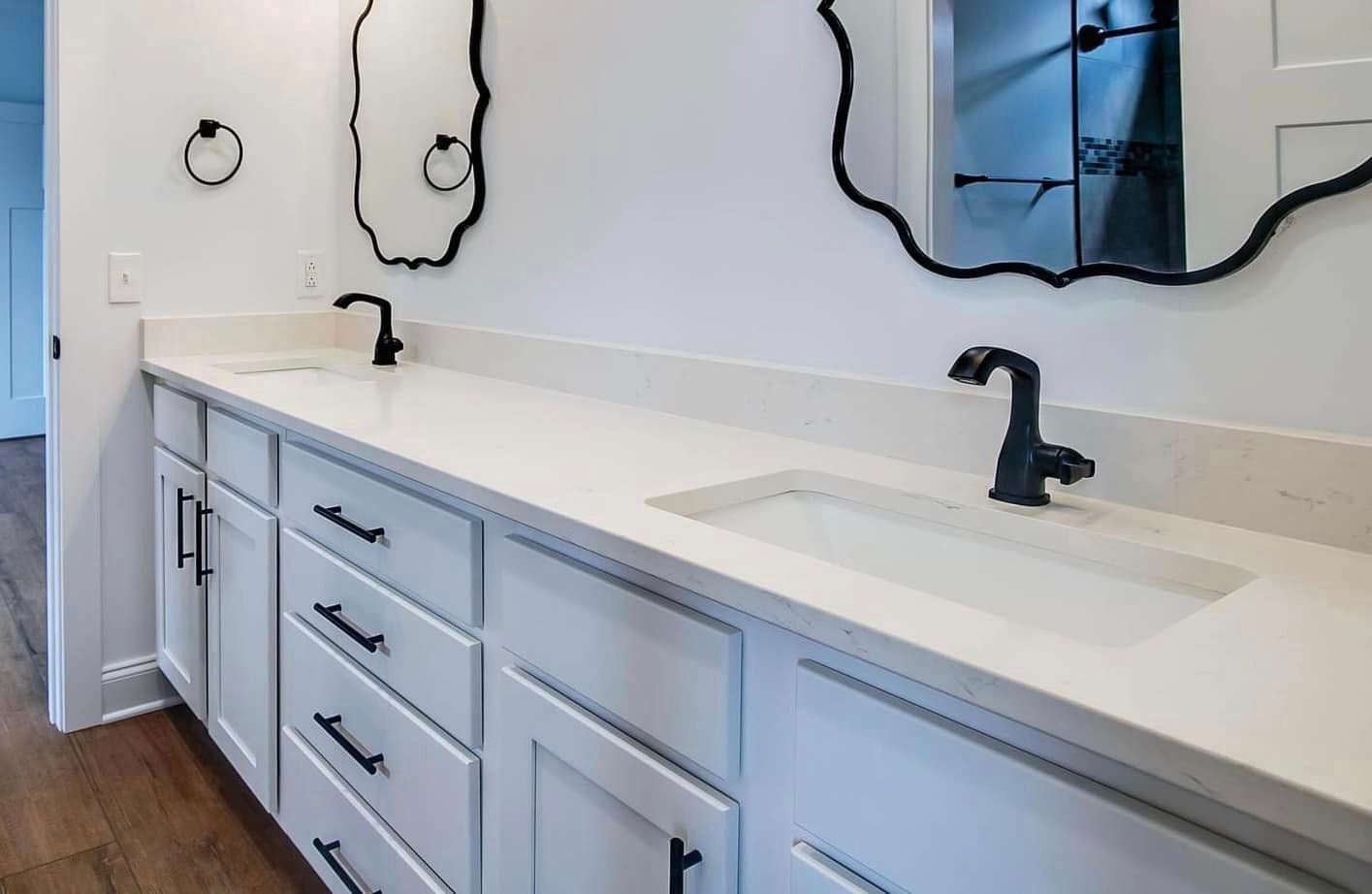 A bathroom with two sinks and a mirror.