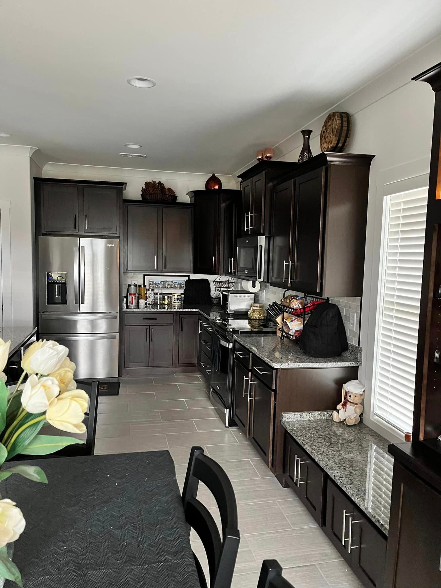 A kitchen with stainless steel appliances and black cabinets