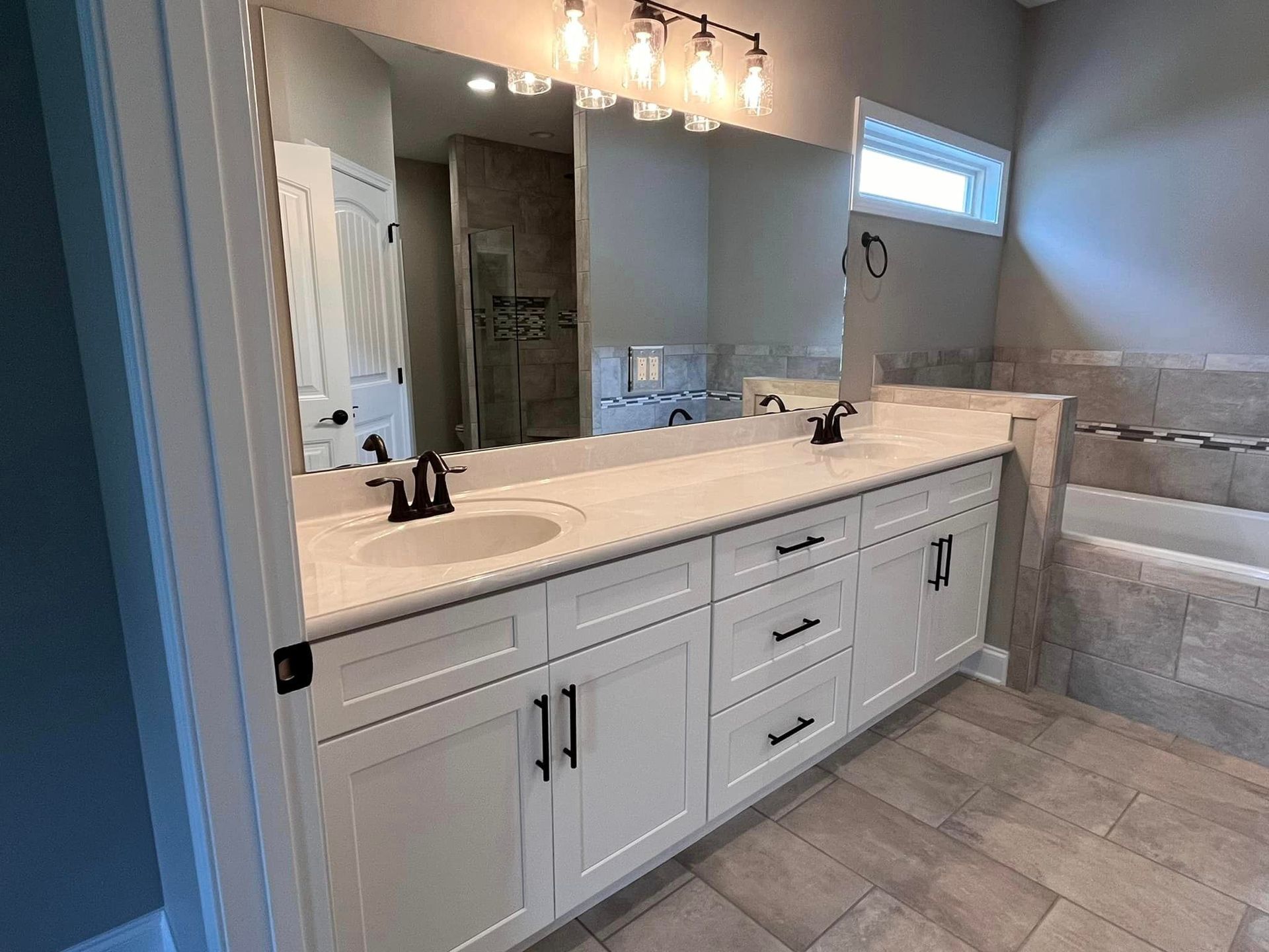 A bathroom with two sinks and a large mirror.