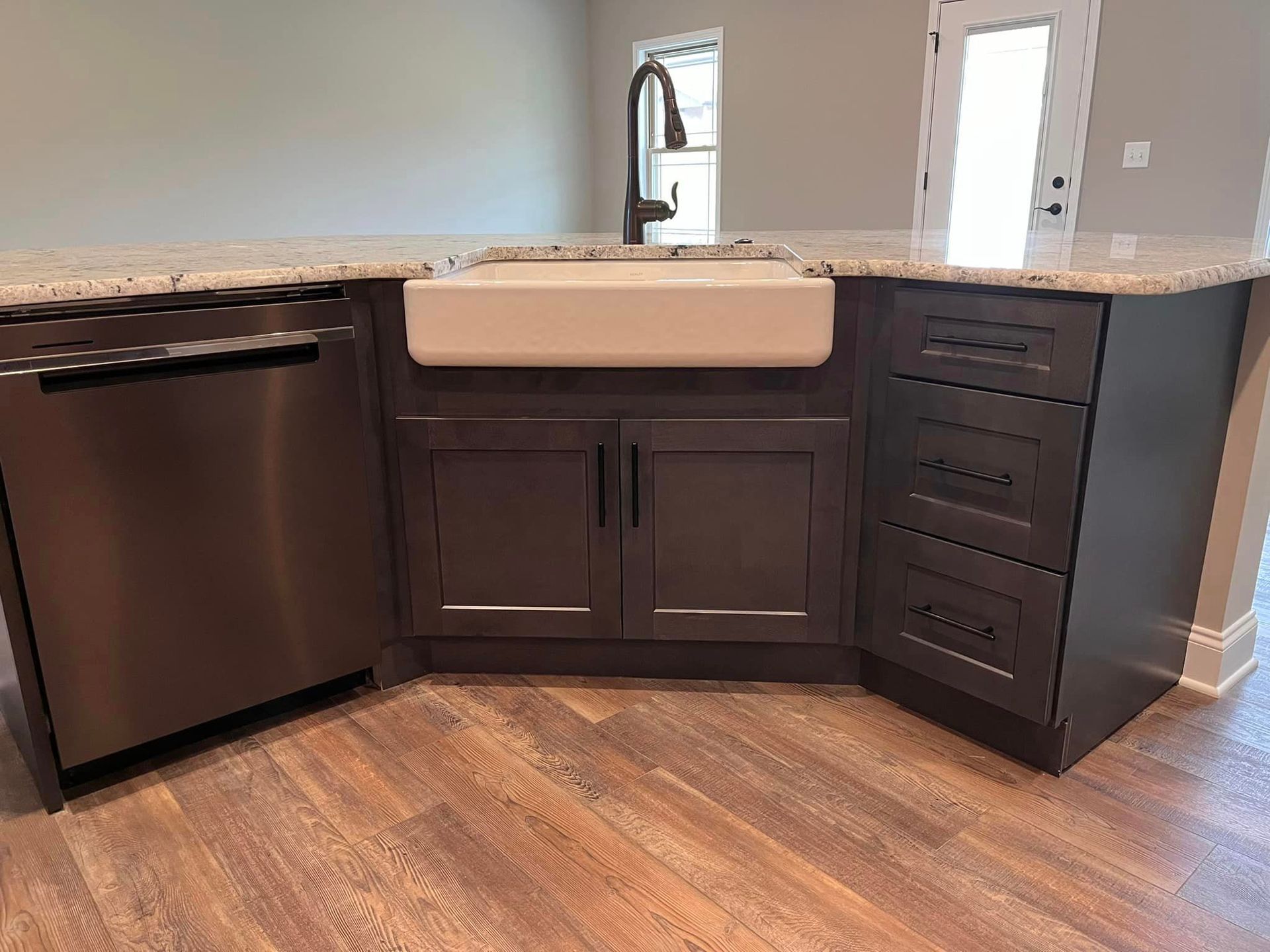 A kitchen with a sink , cabinets , and a stainless steel dishwasher.