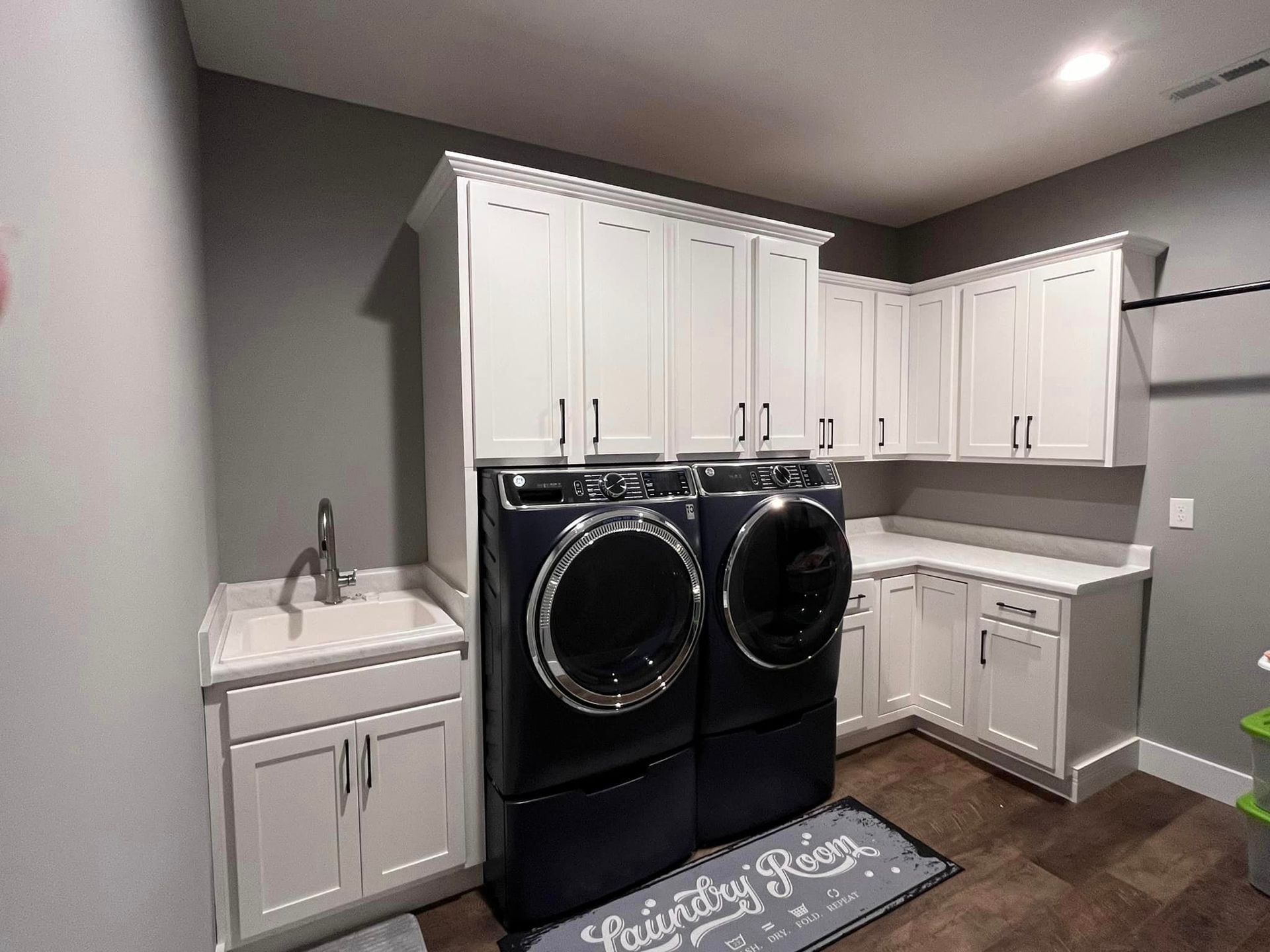 A laundry room with a washer and dryer and a sink.