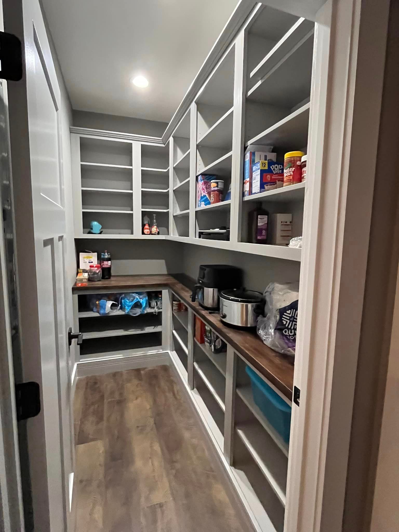 A pantry filled with lots of food and appliances.