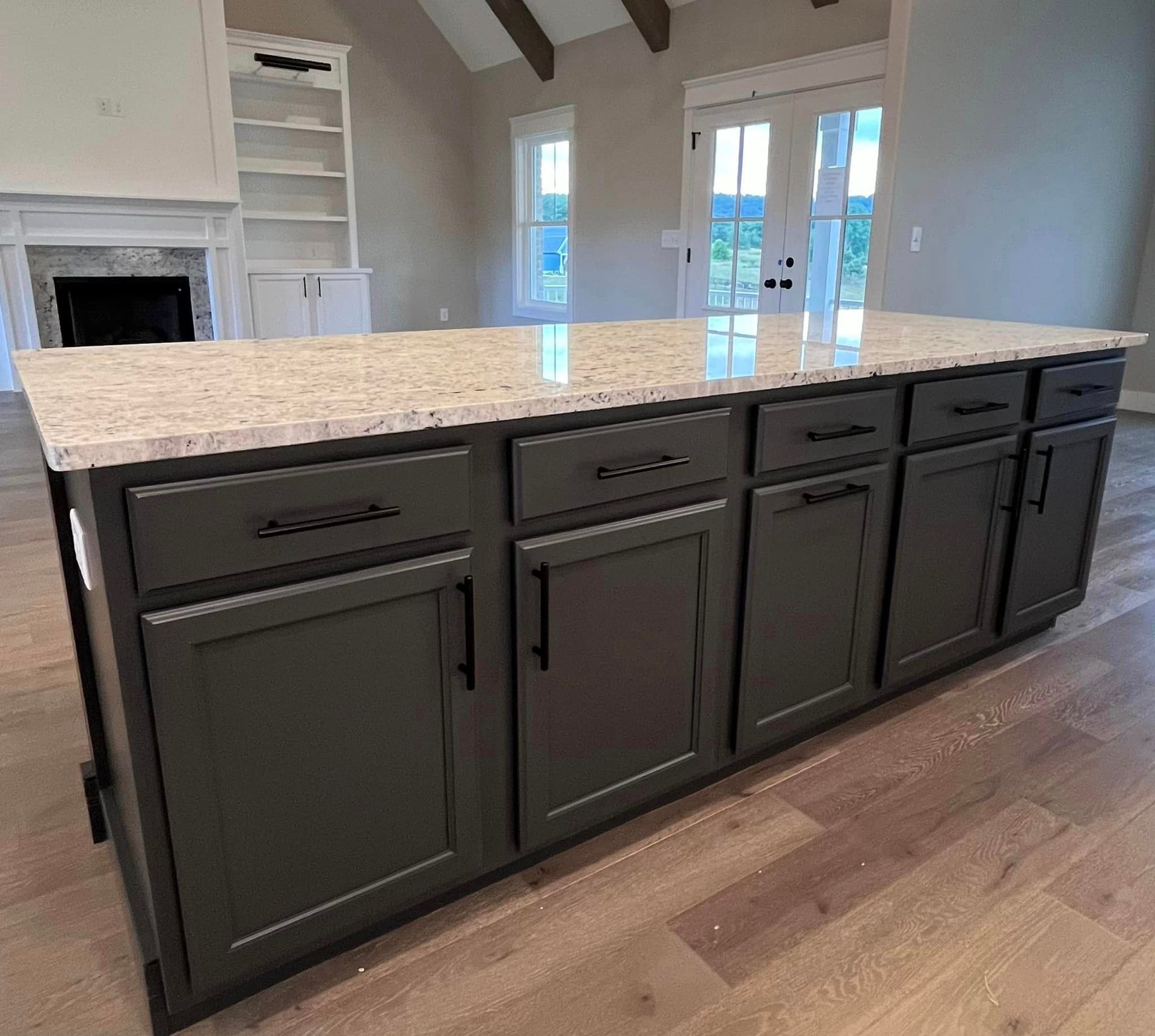 A kitchen with a large island and granite counter tops.
