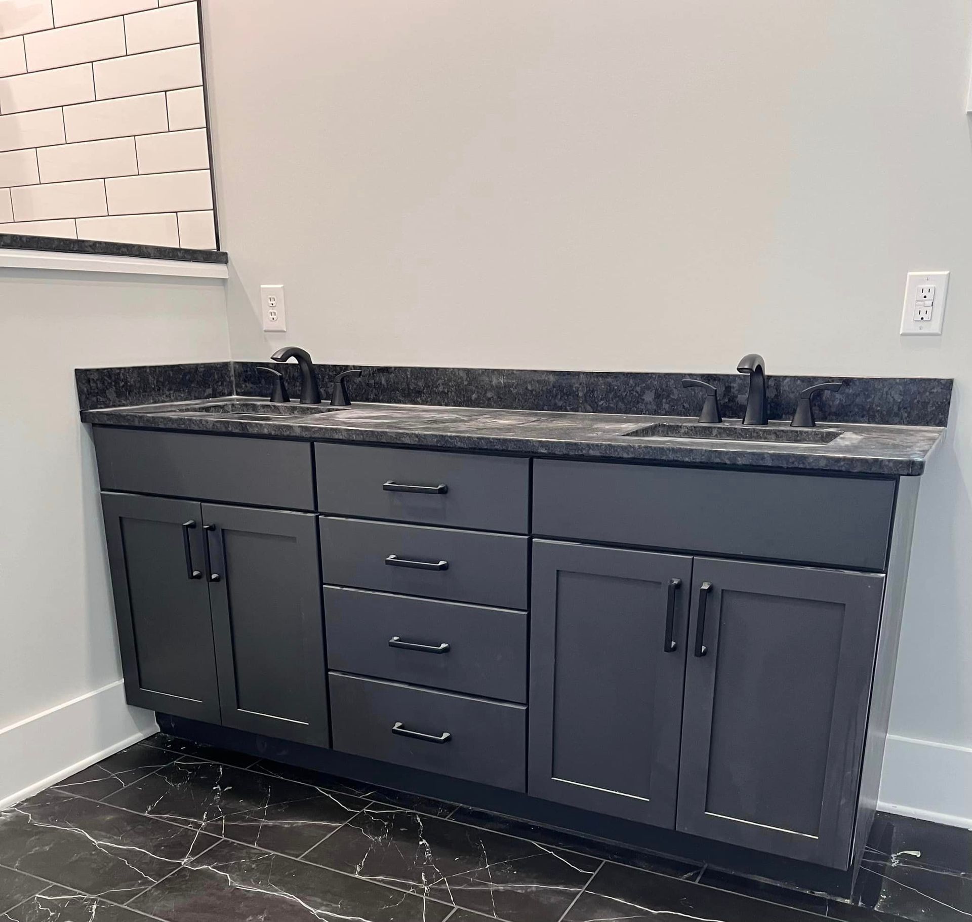 A bathroom vanity with two sinks and black cabinets