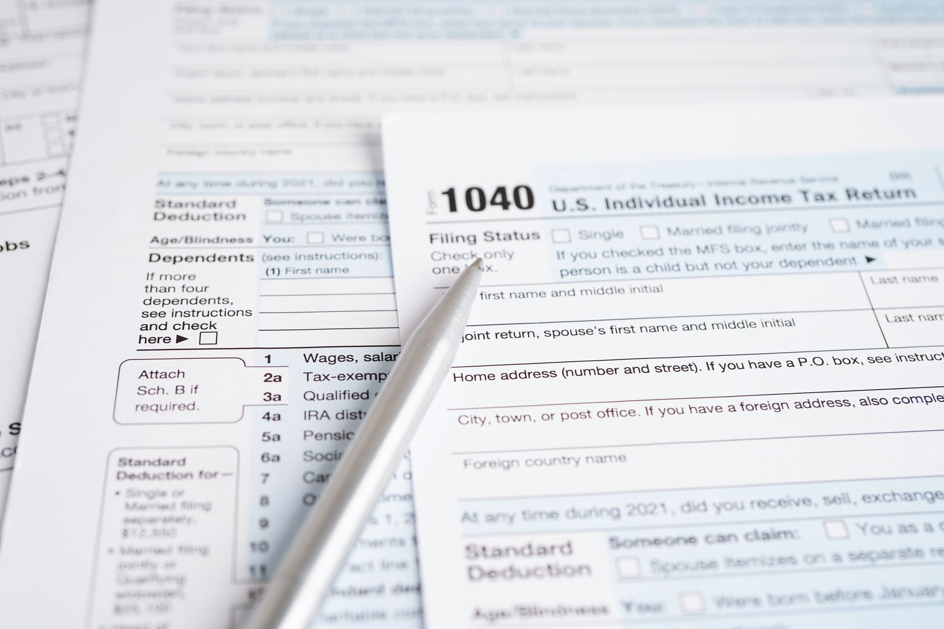 Tax forms and pen on a desk, ready for filing, focus on a 1040 form.