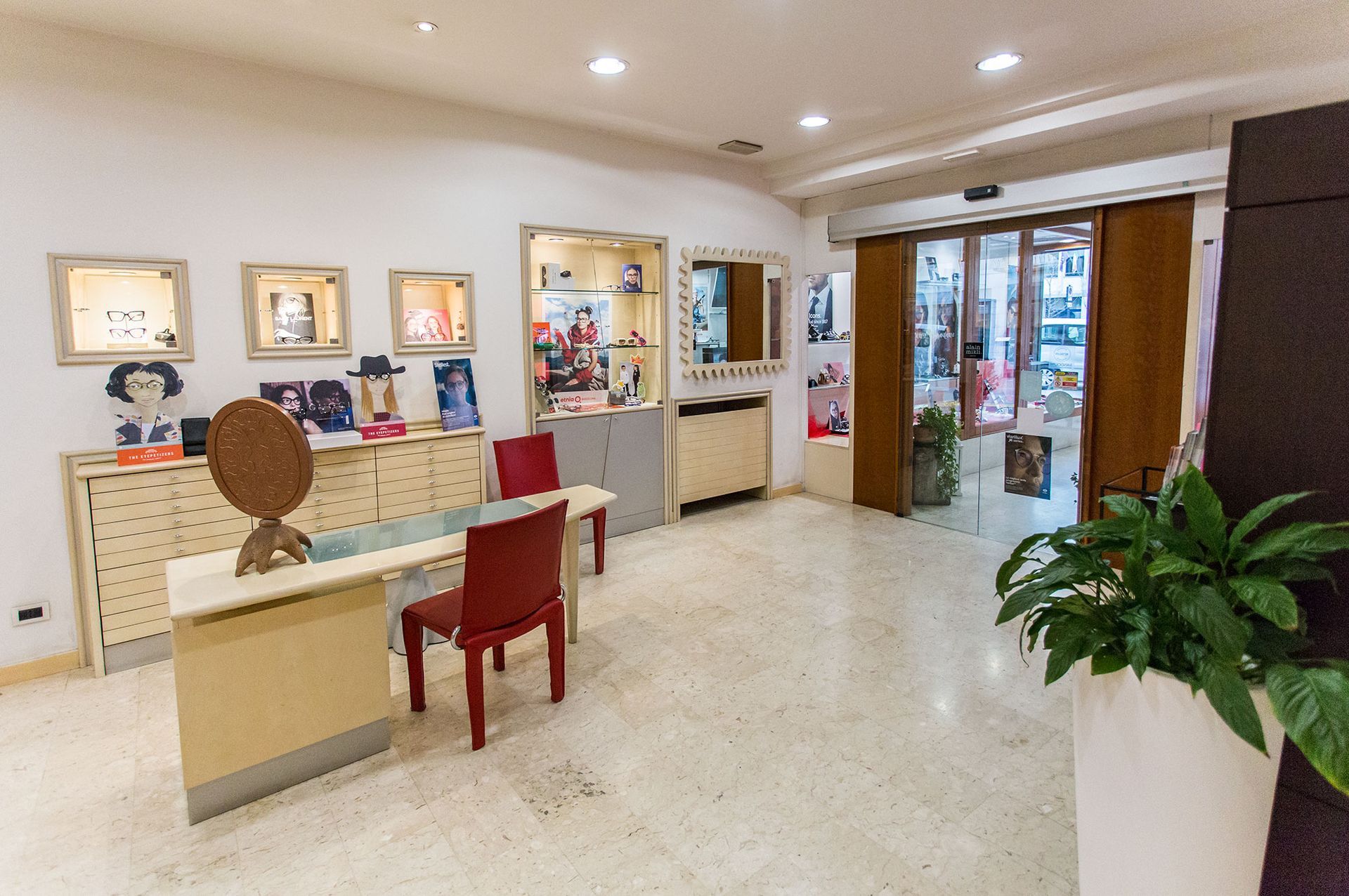 Una stanza con un tavolo, sedie, uno specchio e una pianta.