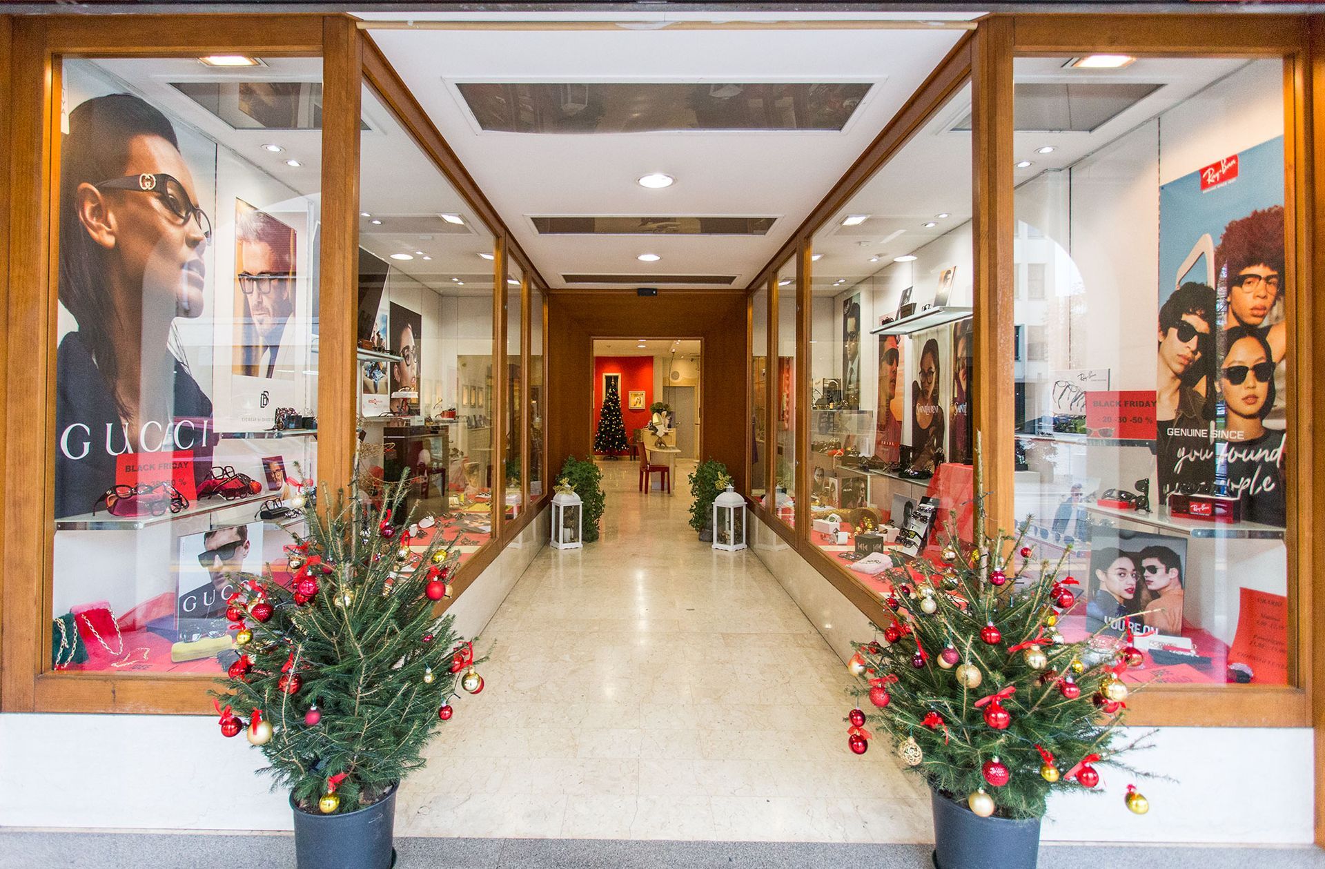 Una vetrina con un'esposizione di occhiali da sole e fiori di fronte