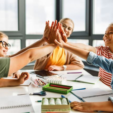 A group of children are giving each other a high five