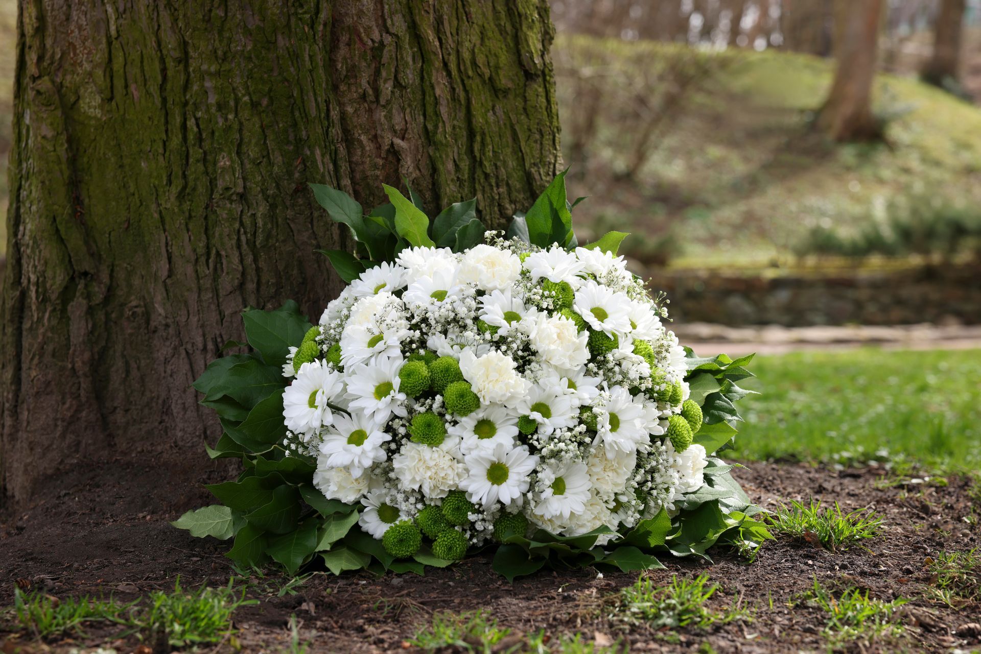 Blumenstrauß Baumstamm Peter Steinel Bestattungen
