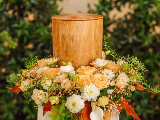 Urne mit hellem Blumenschmuck als Symbol für Feuer- und Urnenbestattung