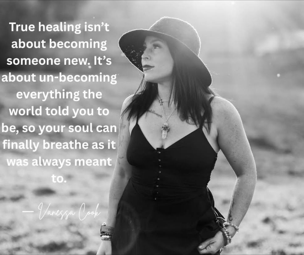 A person sits cross-legged in a sunlit room, playing a small brass singing bowl surrounded by several white crystal bowls.