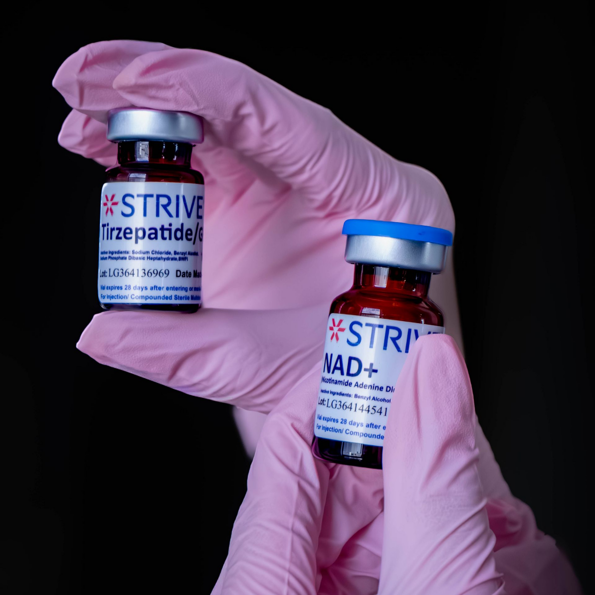 Person in pink gloves holding a saline IV bag labeled 