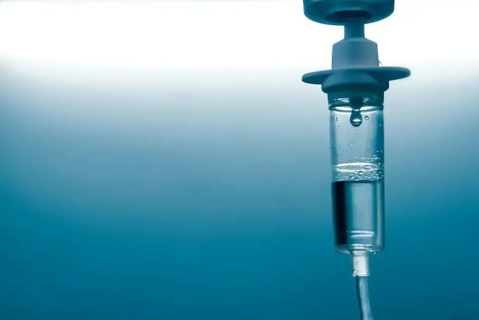 IV drip bag with fluid, hanging against a blue gradient background.