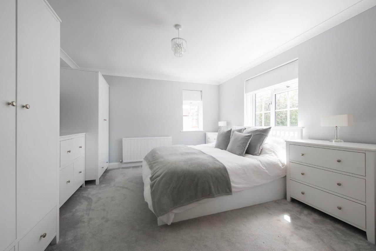 Una camera da letto con un letto, una cassettiera e una finestra.