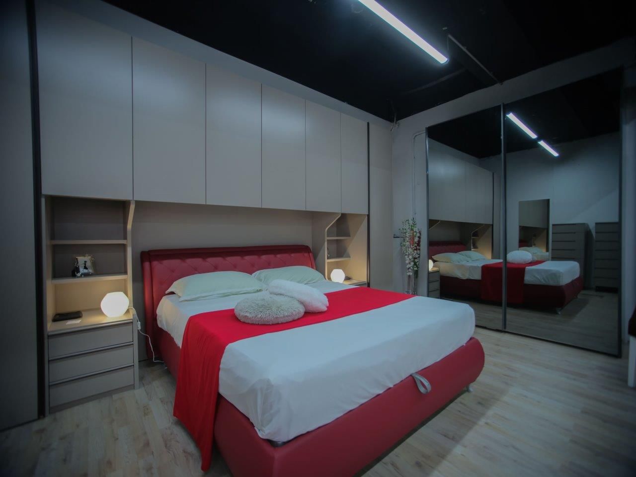 Una camera da letto con un letto rosso e lenzuola bianche