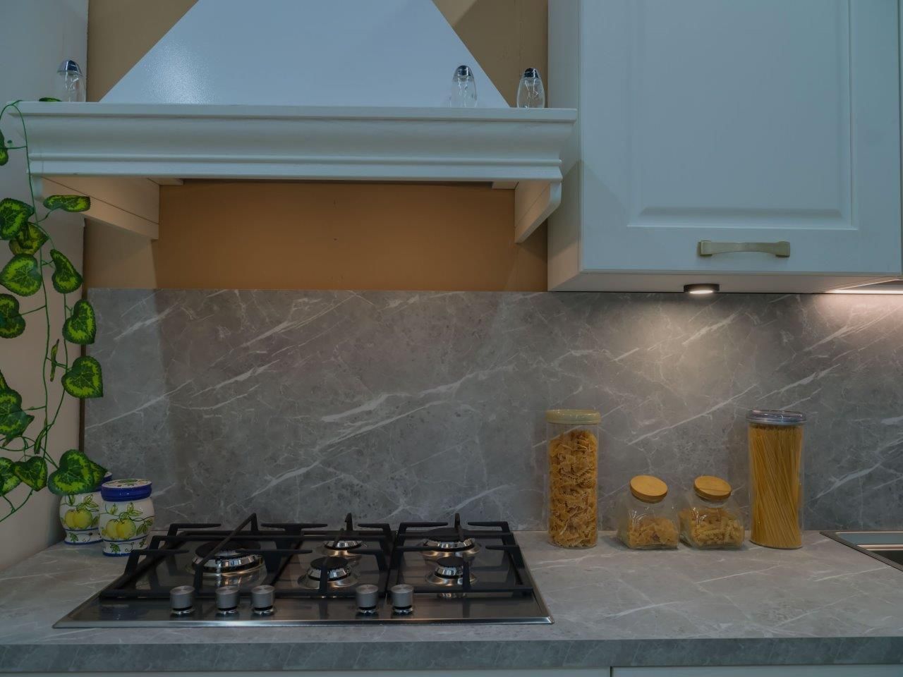 Una cucina con un forno a fornello e barattoli sul bancone