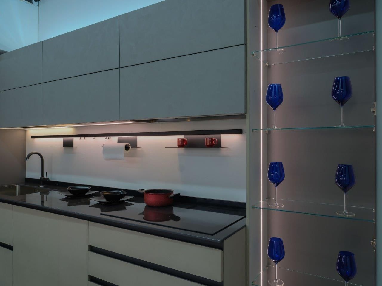 Una cucina con una fila di bicchieri da vino blu sugli scaffali