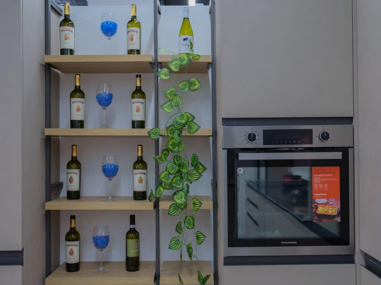 Una cucina con uno scaffale pieno di bottiglie di vino e bicchieri.