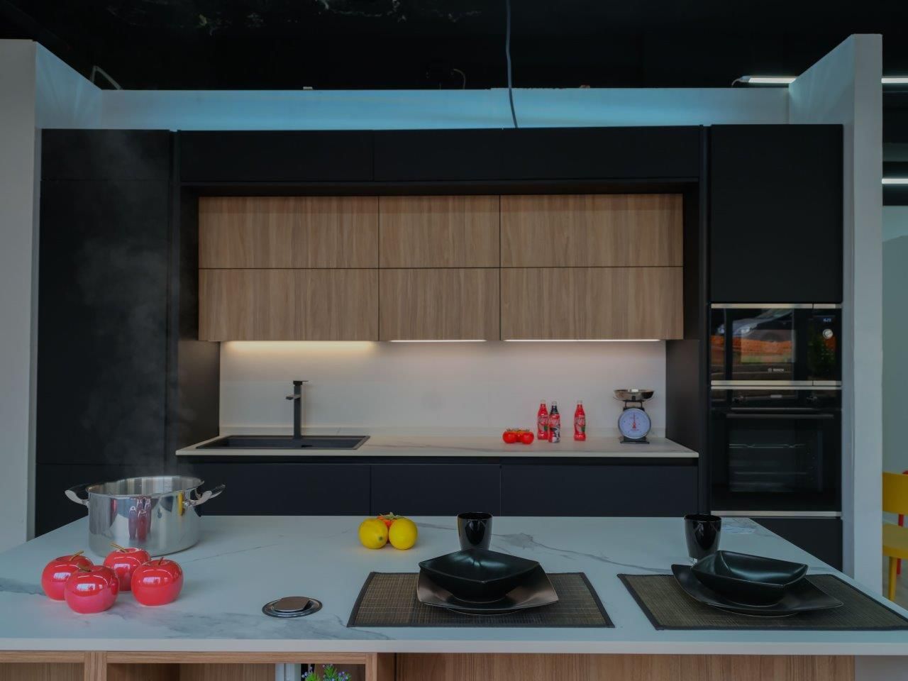 Una cucina con mobili neri e mobili in legno