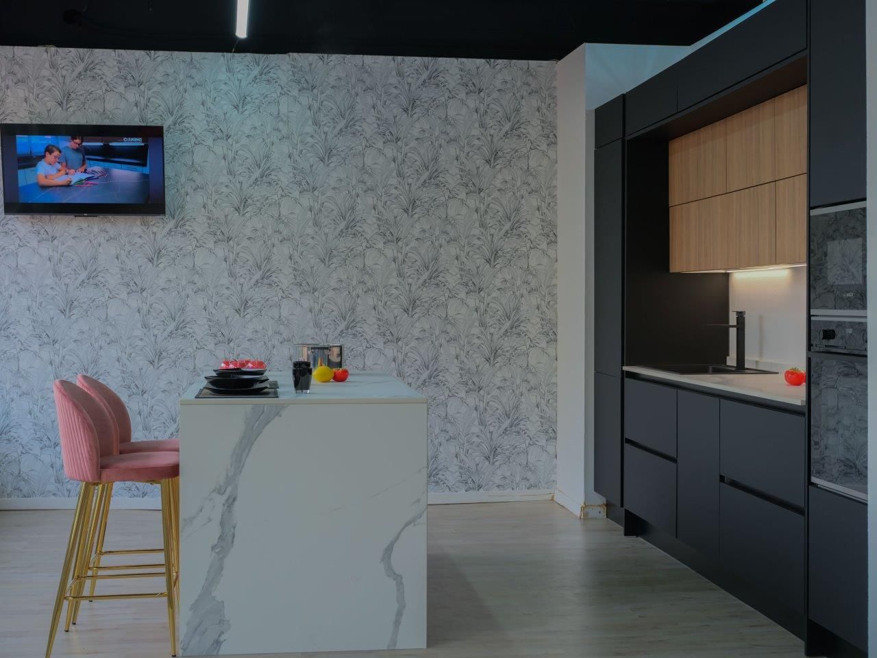 Una cucina con una grande isola e una televisione a parete.