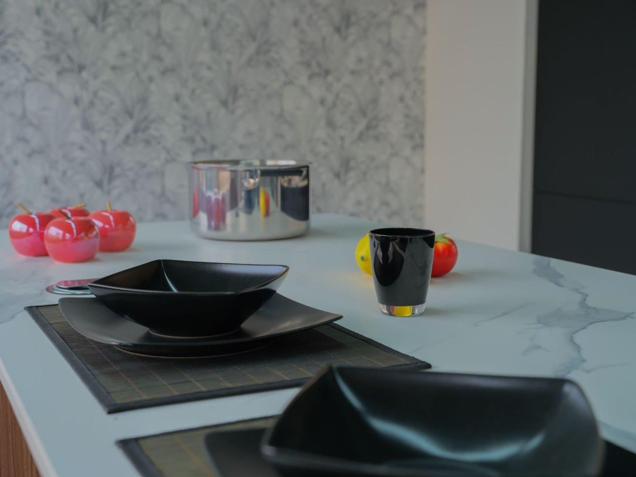 Un bancone della cucina con piatti, ciotole e tazze.