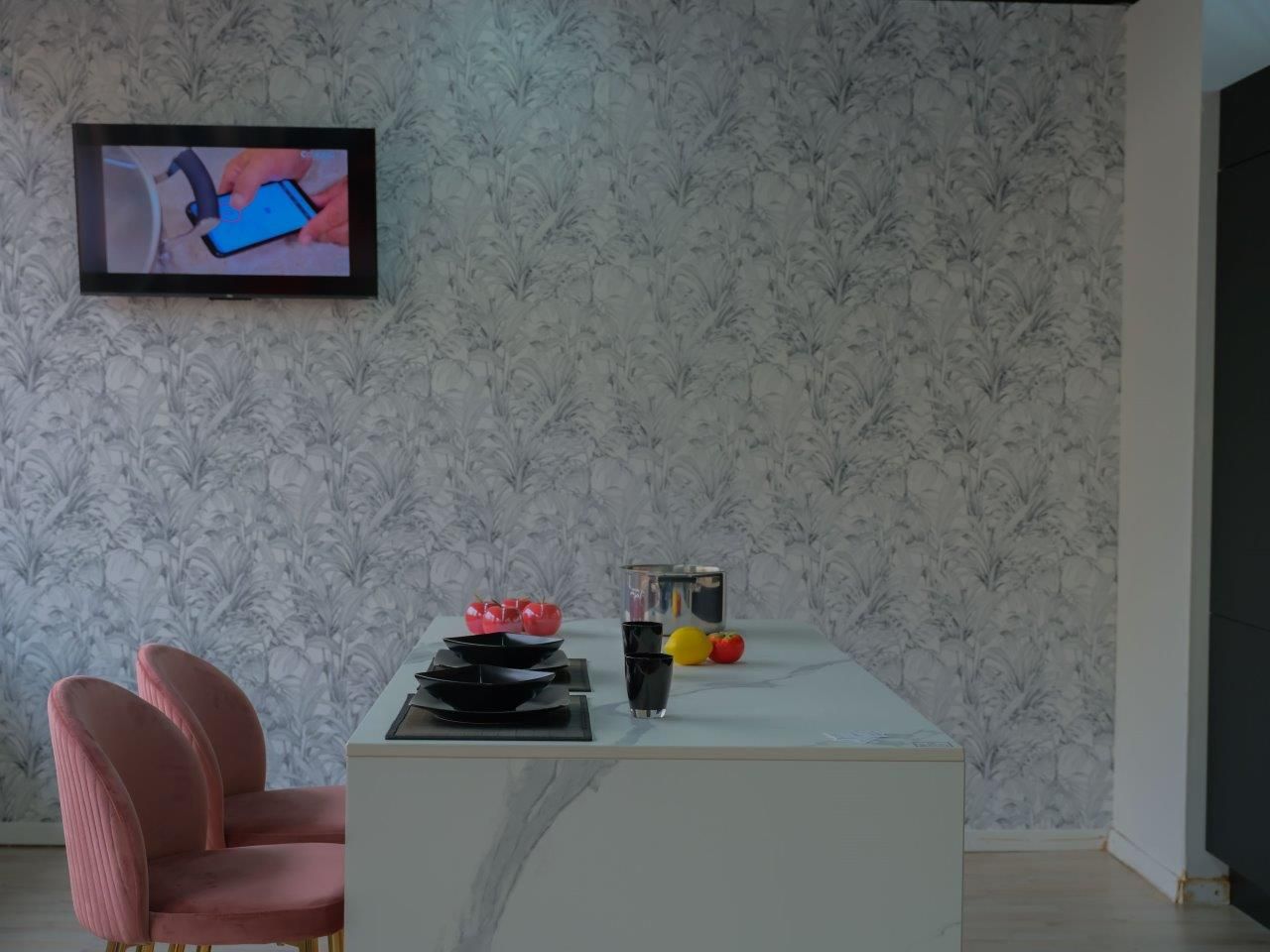 Una sala da pranzo con tavolo, sedie e un televisore a parete.