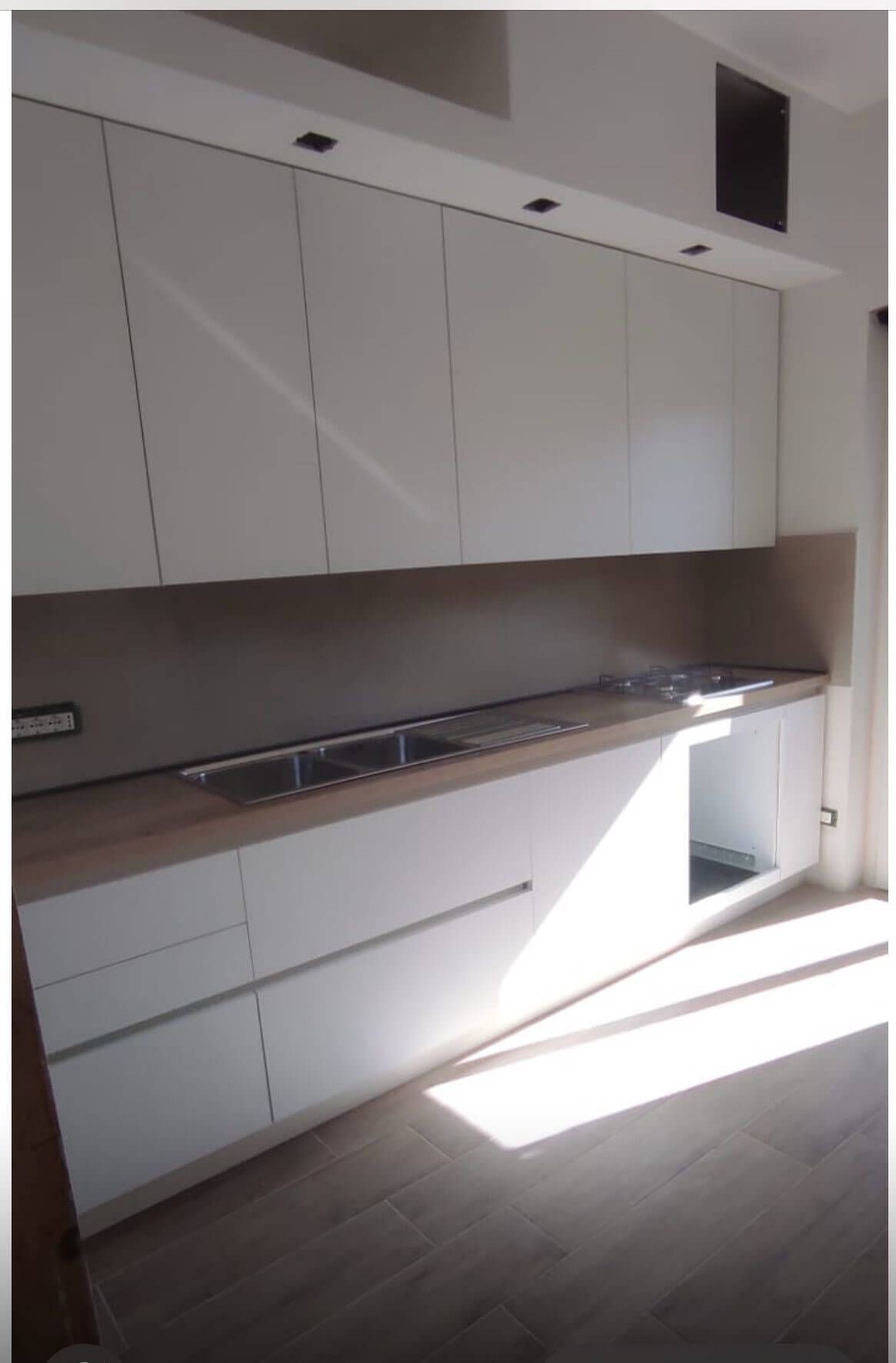 Una cucina con mobili bianchi e un lavello