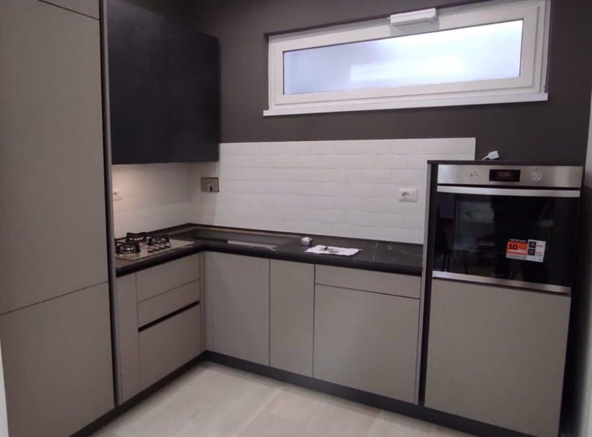 Una cucina con elettrodomestici in acciaio inossidabile e una finestra