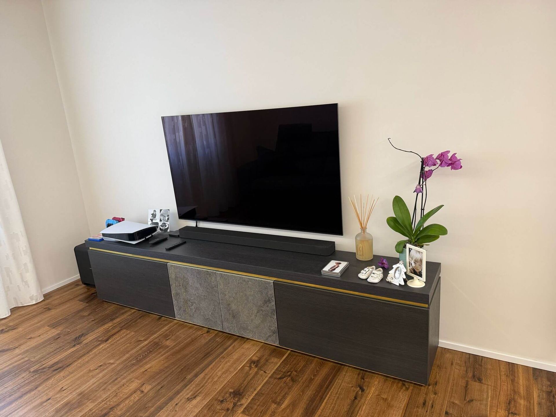 Nel soggiorno è presente una TV a schermo piatto appoggiata su un mobile porta TV in legno.