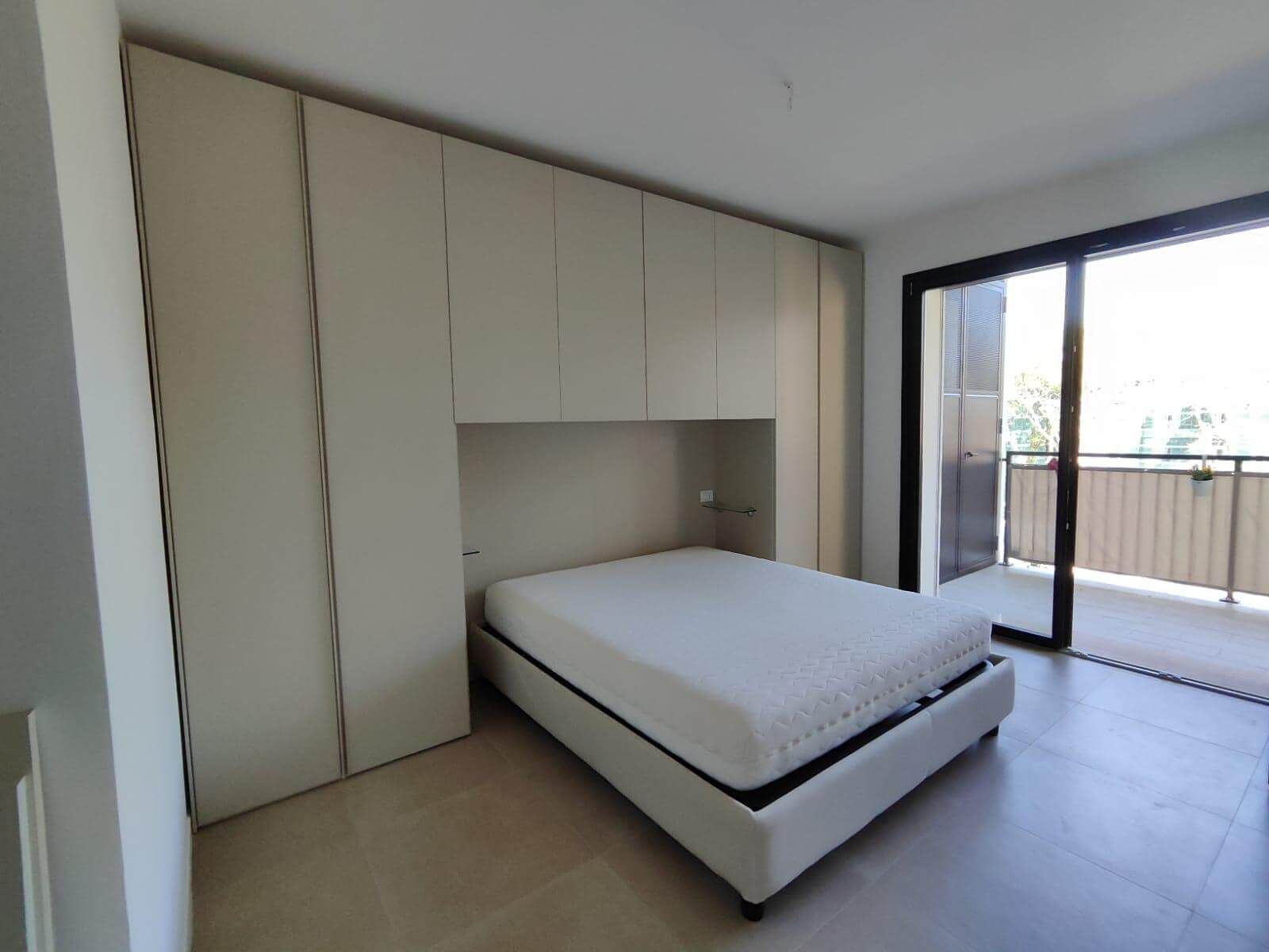 Una camera da letto con un letto e una porta scorrevole in vetro