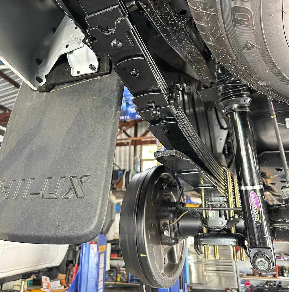 A Hilux Truck is Sitting on a Lift in a Garage — RNA Mechanical In Coolum, QLD