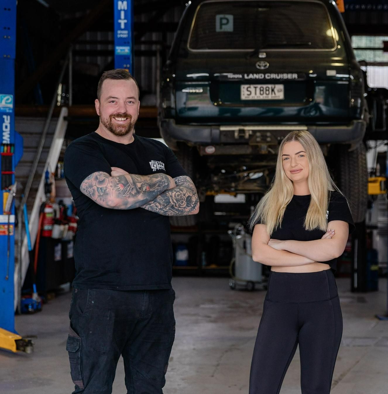 A Man And A Woman Standing In Front Of A Land Cruiser — RNA Mechanical In Yandina, QLD