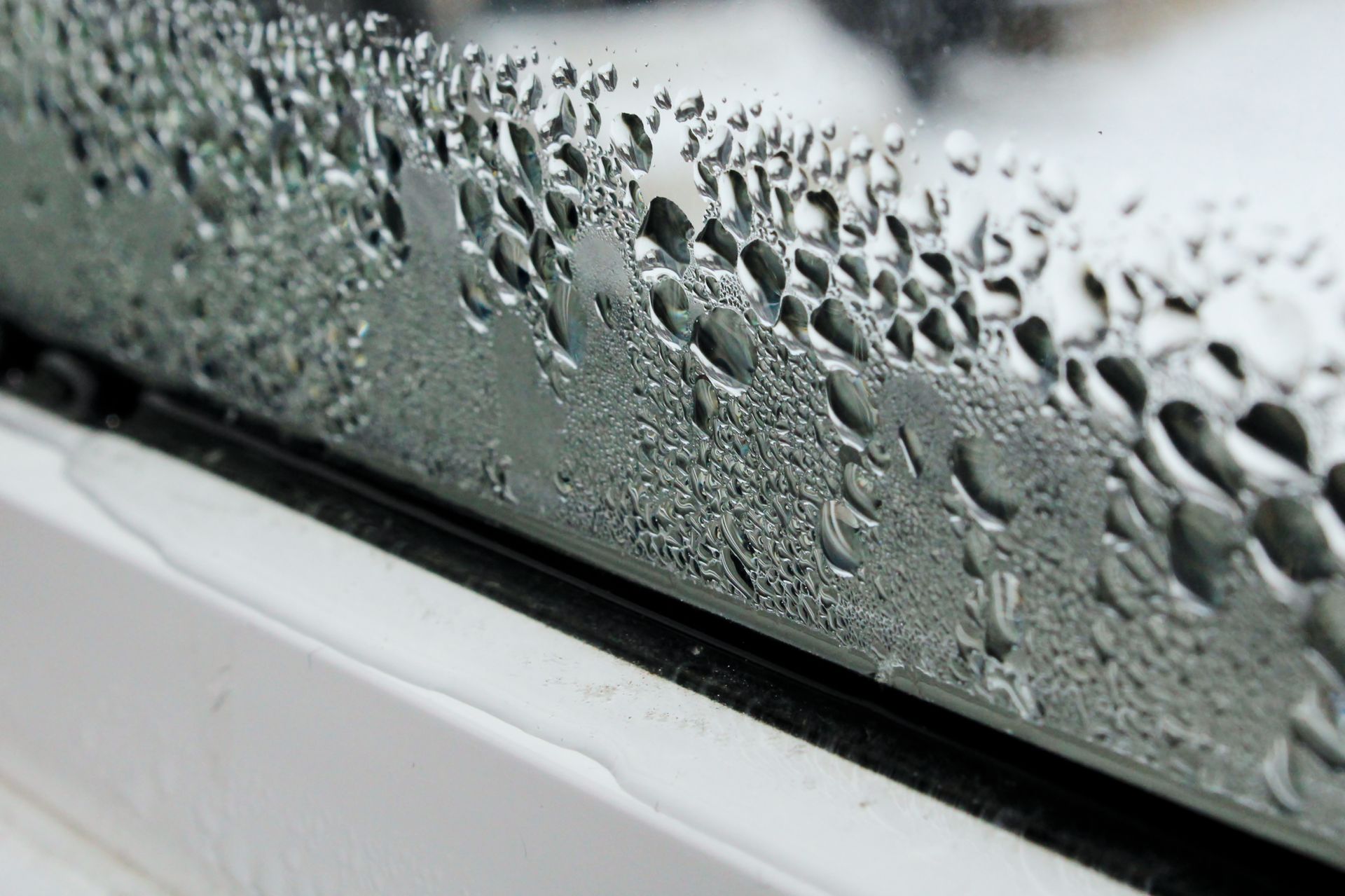 A close up of a window with water drops on it.